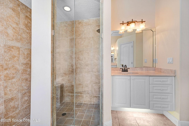 bathroom featuring a stall shower, tile patterned flooring, vanity, and a textured ceiling