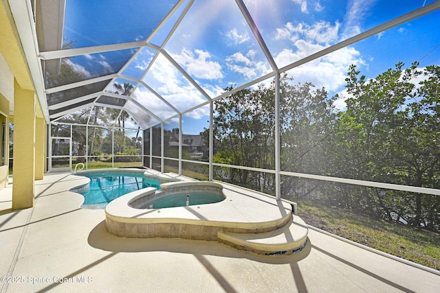 view of swimming pool with glass enclosure, a pool with connected hot tub, and a patio