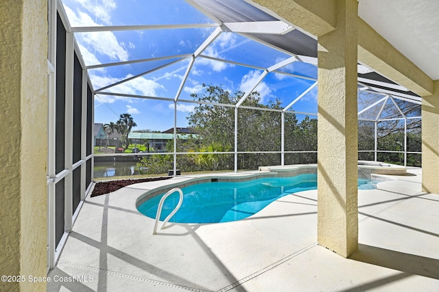 view of swimming pool featuring a patio area, a lanai, and a pool with connected hot tub