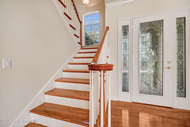 entryway featuring stairs, baseboards, and wood finished floors