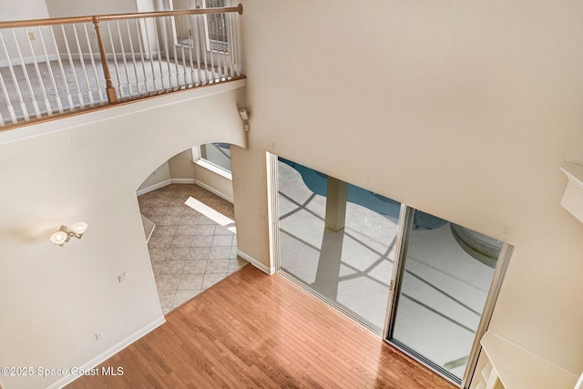 interior space featuring baseboards, arched walkways, and wood finished floors