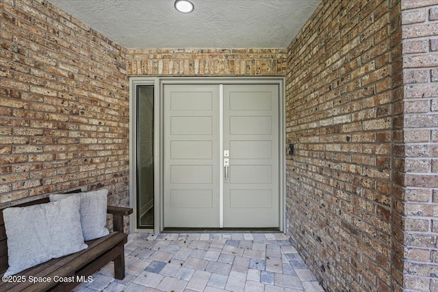 property entrance featuring brick siding