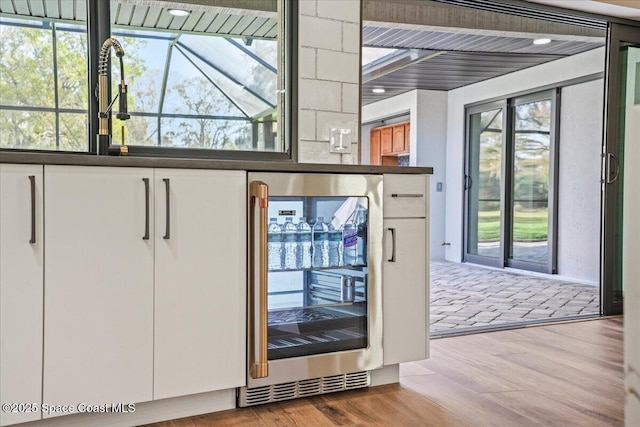 doorway to outside featuring wine cooler and wood finished floors