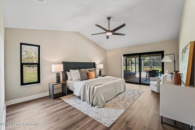 bedroom featuring access to exterior, a ceiling fan, vaulted ceiling, wood finished floors, and baseboards