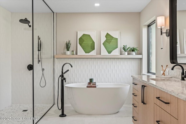 full bath with a soaking tub, tile patterned flooring, a walk in shower, and vanity