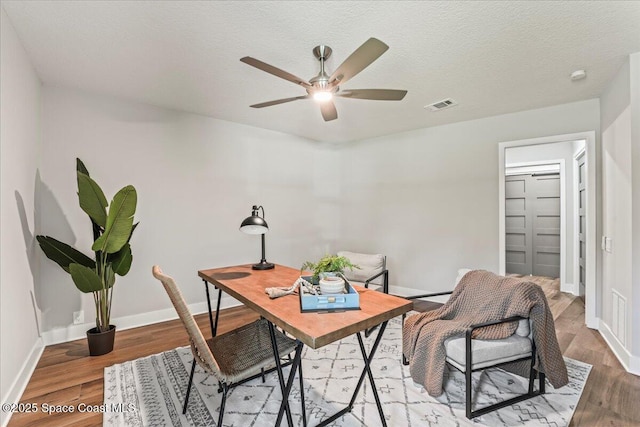 home office featuring wood finished floors, visible vents, and baseboards