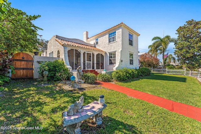 back of property featuring fence private yard, a tile roof, a yard, a gate, and stucco siding