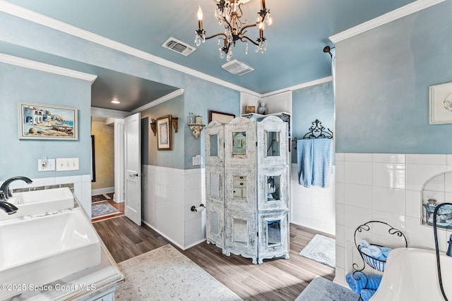 2109 Indian River Dr, Cocoa, FL 32922 - full bathroom featuring tile walls, wood finished floors, a soaking tub, a chandelier, and ornamental molding