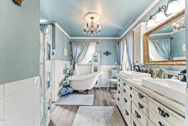 2109 Indian River Dr, Cocoa, FL 32922 - bathroom with a chandelier, tile walls, crown molding, double vanity, and a freestanding bath