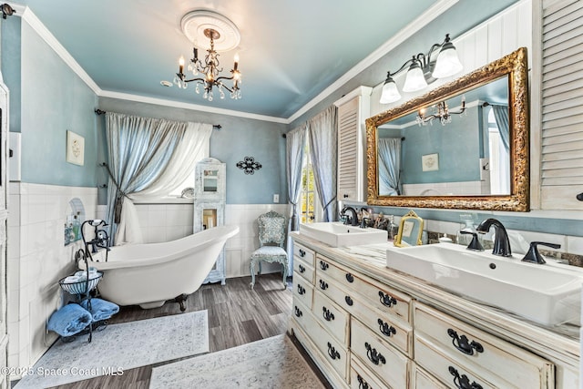 2109 Indian River Dr, Cocoa, FL 32922 - bathroom with a chandelier, tile walls, a wainscoted wall, double vanity, and a freestanding tub