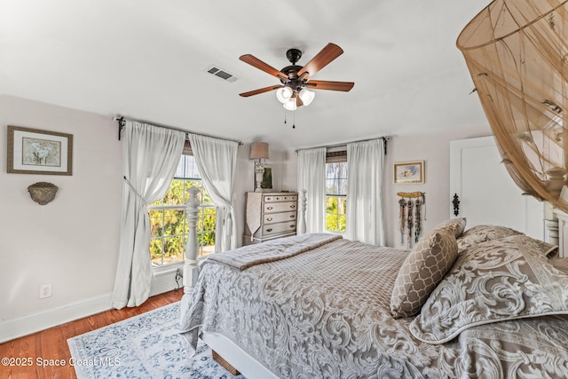 2109 Indian River Dr, Cocoa, FL 32922 - bedroom with multiple windows, baseboards, wood finished floors, and a ceiling fan
