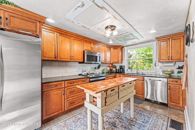 2109 Indian River Dr, Cocoa, FL 32922 - kitchen with stainless steel appliances, a sink, tasteful backsplash, brown cabinetry, and recessed lighting