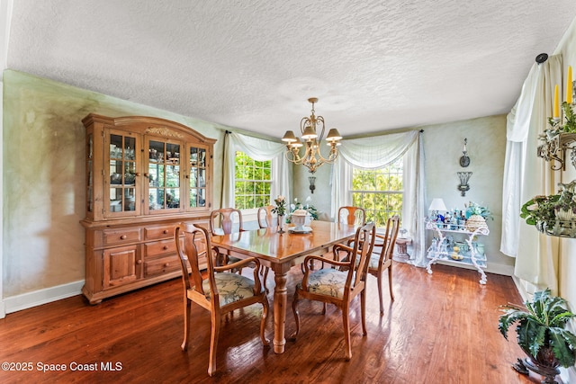 2109 Indian River Dr, Cocoa, FL 32922 - dining room featuring a chandelier, dark wood-type flooring, a textured ceiling, and baseboards
