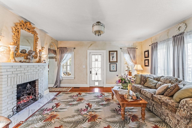 2109 Indian River Dr, Cocoa, FL 32922 - living room featuring a brick fireplace, baseboards, and wood finished floors