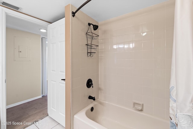 bathroom featuring shower / bath combination with curtain, tile patterned flooring, visible vents, and baseboards