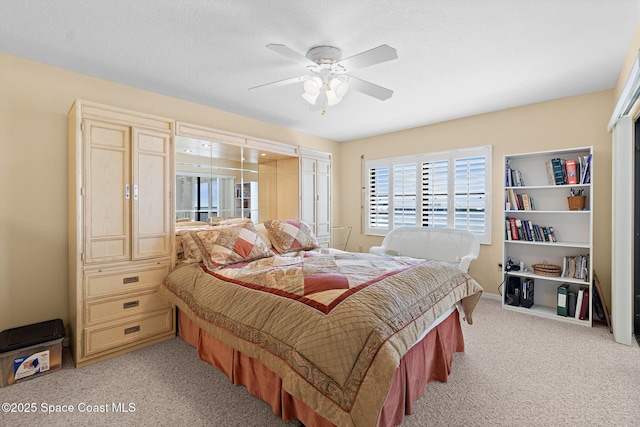 bedroom with light carpet and a ceiling fan