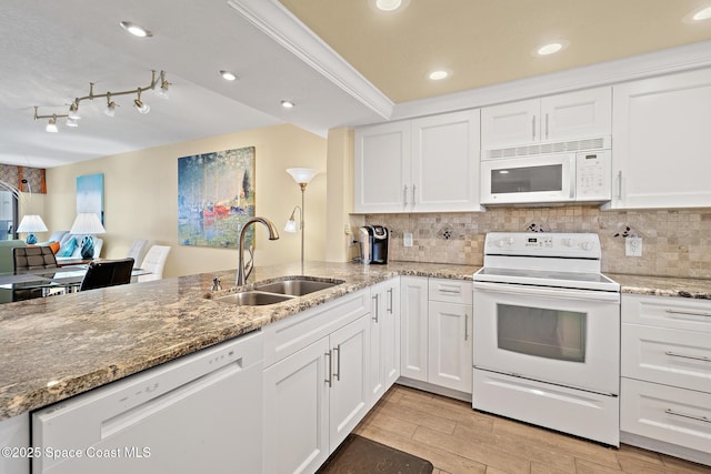 kitchen featuring tasteful backsplash, light wood-style floors, white cabinetry, a sink, and white appliances