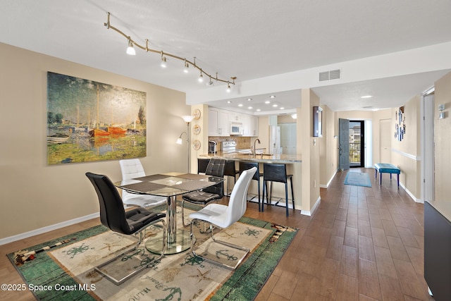 dining room with dark wood-type flooring, recessed lighting, visible vents, and baseboards