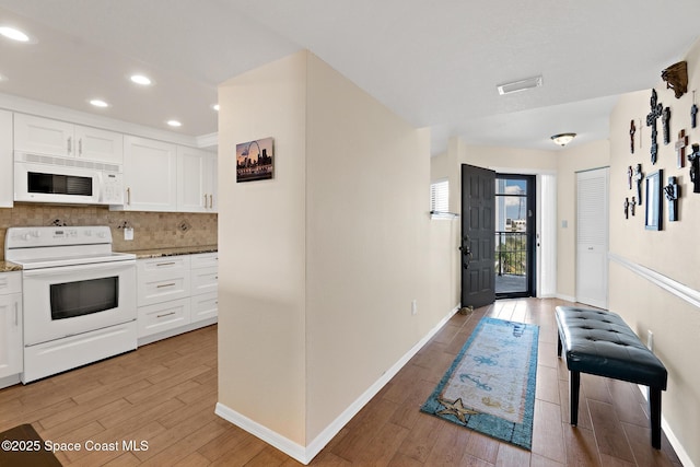 entrance foyer featuring recessed lighting, light wood-style flooring, and baseboards