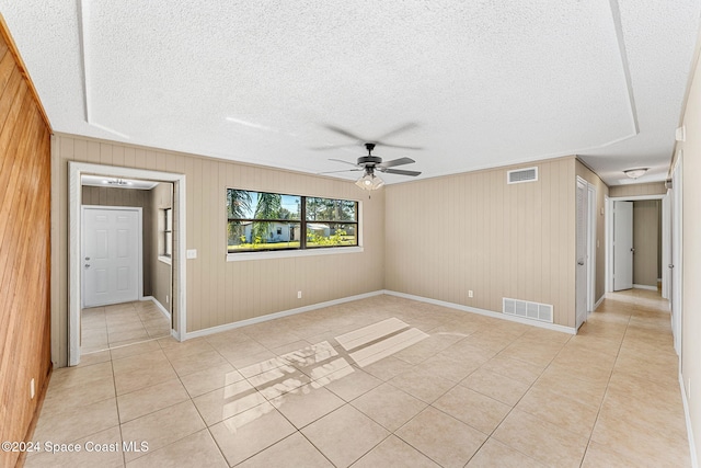 spare room with a ceiling fan, visible vents, a textured ceiling, and light tile patterned floors