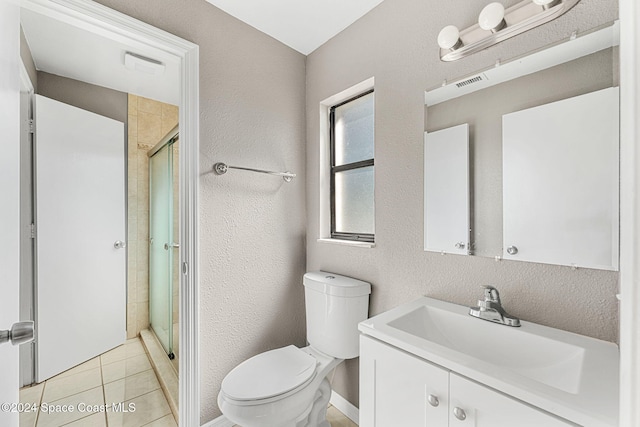 bathroom featuring a textured wall, toilet, a shower stall, vanity, and tile patterned flooring