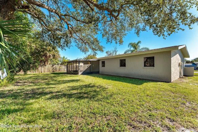 view of yard with fence and a sunroom