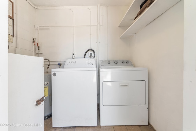 laundry room featuring water heater, laundry area, and washer and dryer