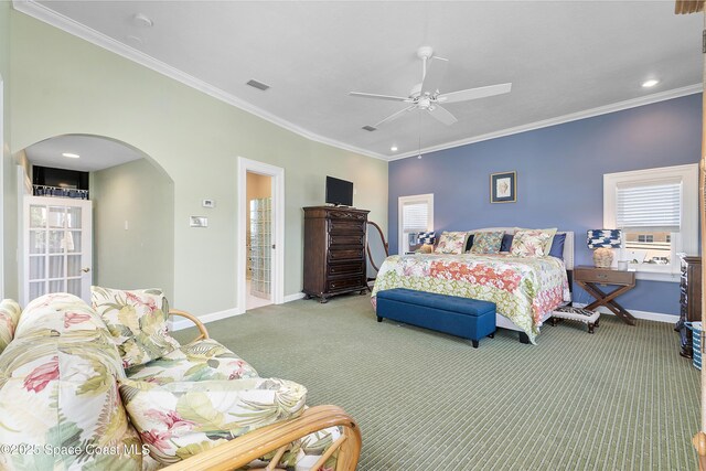 carpeted bedroom featuring arched walkways, a ceiling fan, baseboards, visible vents, and crown molding