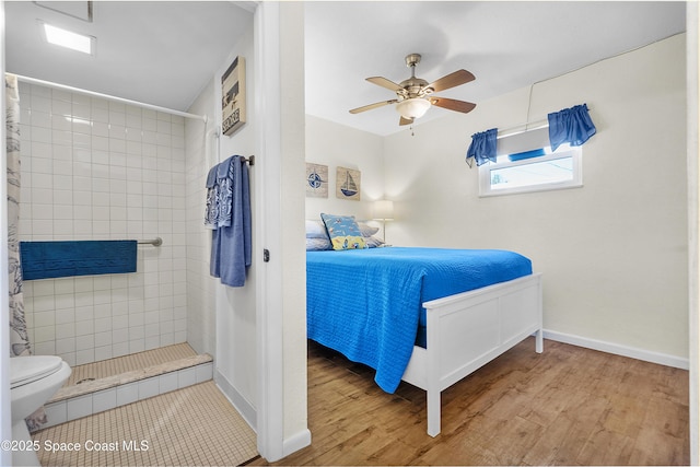 bedroom featuring a ceiling fan, baseboards, and wood finished floors