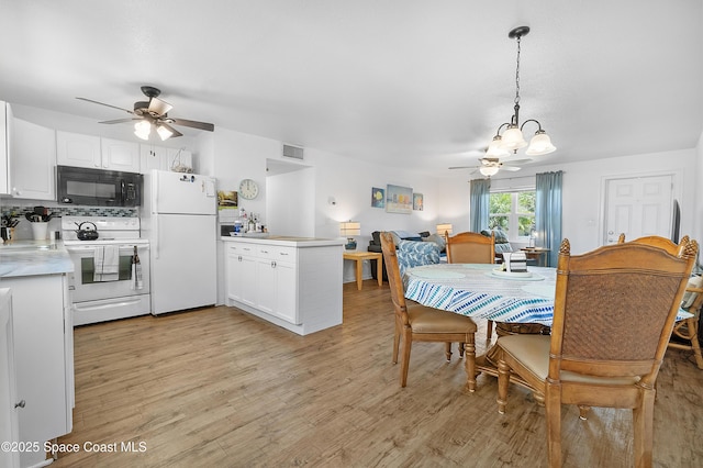 dining area featuring light wood finished floors, visible vents, and a ceiling fan