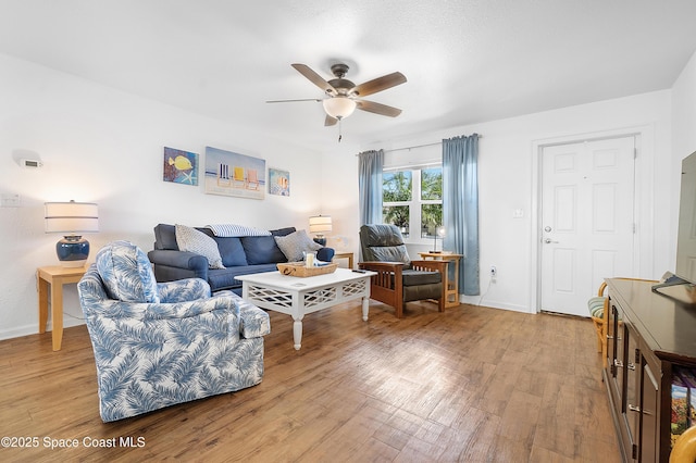 living room with ceiling fan, light wood-style flooring, and baseboards