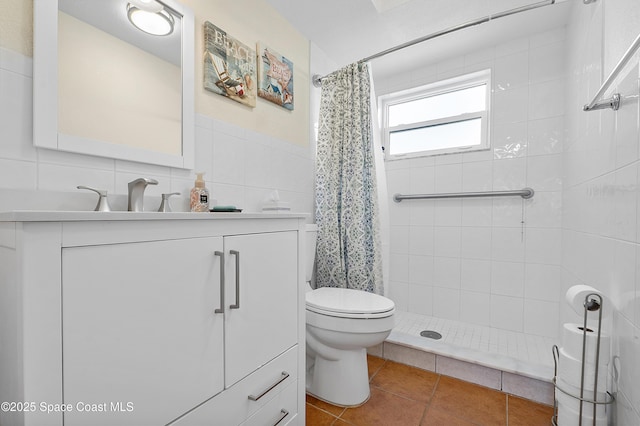 full bath featuring tile walls, toilet, vanity, tiled shower, and tile patterned floors