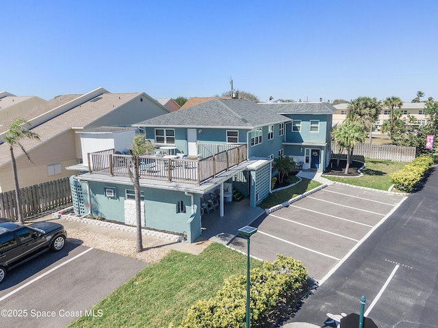 exterior space featuring a residential view, fence, uncovered parking, and stucco siding