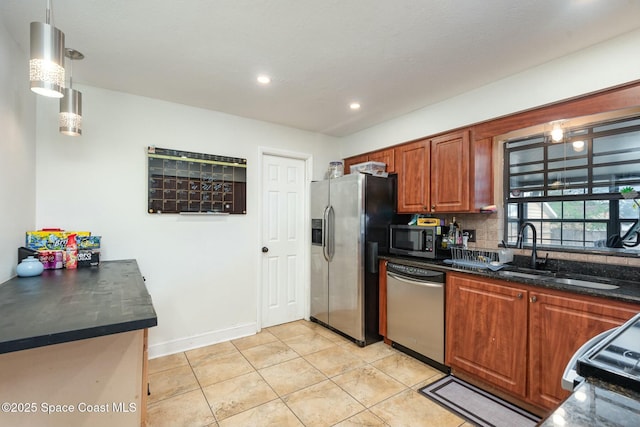 kitchen featuring brown cabinets, light tile patterned floors, stainless steel appliances, decorative backsplash, and a sink