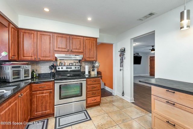 kitchen featuring electric range, visible vents, decorative backsplash, brown cabinetry, and under cabinet range hood