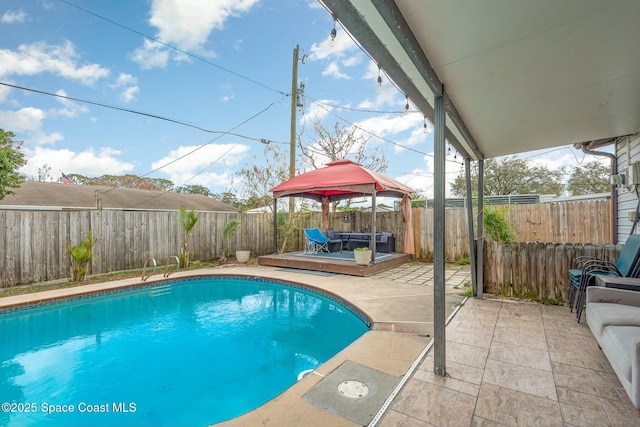 view of pool with a fenced backyard, a patio area, a wooden deck, and a fenced in pool