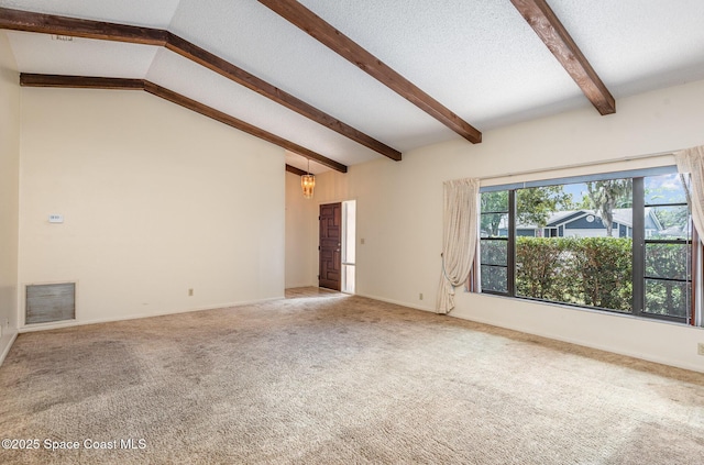 carpeted empty room with lofted ceiling with beams, a textured ceiling, visible vents, and baseboards