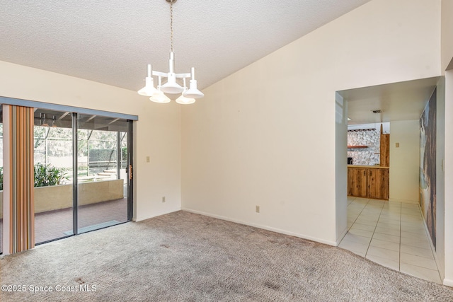 empty room featuring light carpet, light tile patterned floors, vaulted ceiling, and an inviting chandelier