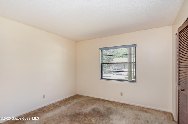 unfurnished bedroom with carpet, a textured ceiling, baseboards, and a closet