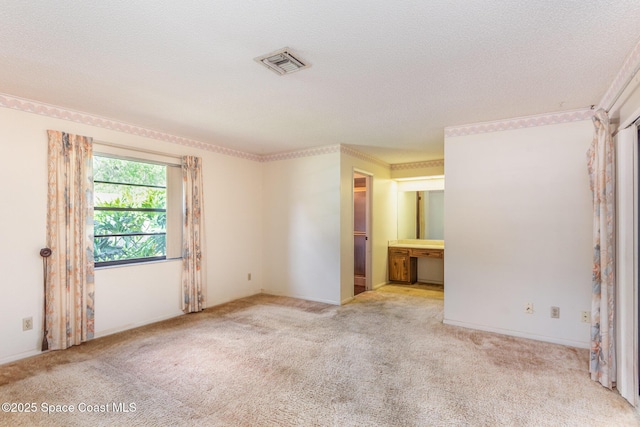 unfurnished room featuring carpet, visible vents, and a textured ceiling