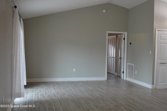 6110 Grissom Pkwy, Cocoa, FL 32927 - empty room with baseboards, visible vents, wood finished floors, and high vaulted ceiling