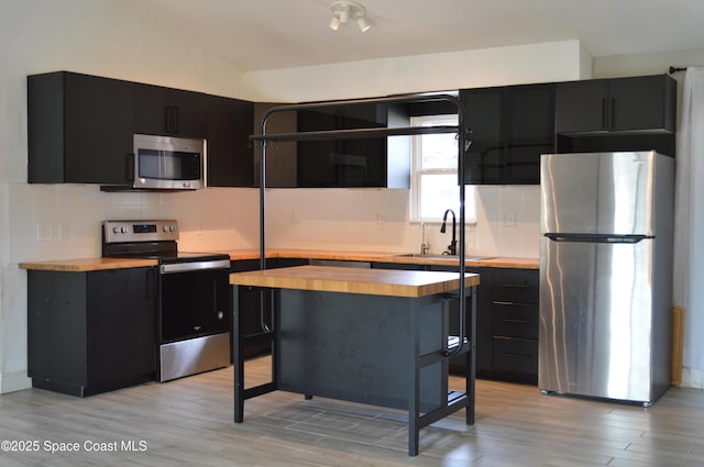 6110 Grissom Pkwy, Cocoa, FL 32927 - kitchen featuring appliances with stainless steel finishes, dark cabinetry, and butcher block countertops
