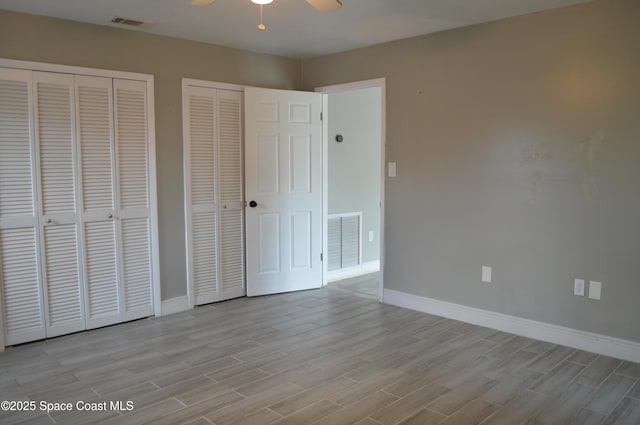 6110 Grissom Pkwy, Cocoa, FL 32927 - unfurnished bedroom with multiple closets, baseboards, wood finished floors, and visible vents