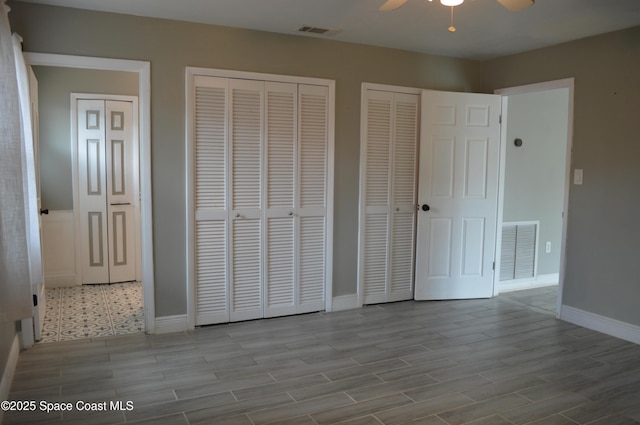 6110 Grissom Pkwy, Cocoa, FL 32927 - unfurnished bedroom featuring two closets, baseboards, visible vents, and wood finished floors