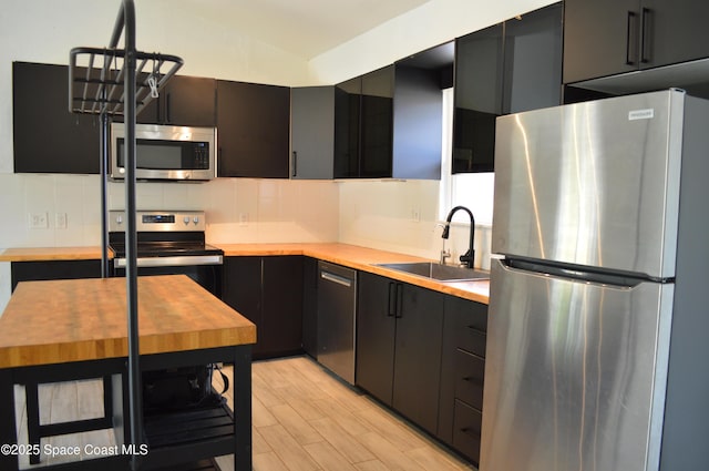 6110 Grissom Pkwy, Cocoa, FL 32927 - kitchen featuring appliances with stainless steel finishes, a sink, dark cabinetry, backsplash, and butcher block counters
