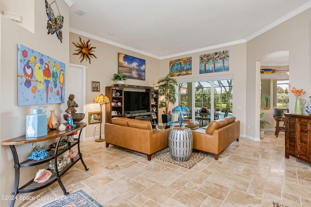 living area with arched walkways, ornamental molding, visible vents, and baseboards