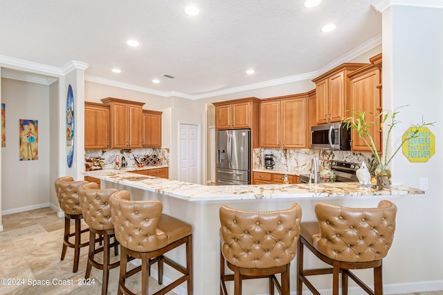 kitchen featuring appliances with stainless steel finishes, brown cabinets, a peninsula, and light stone countertops