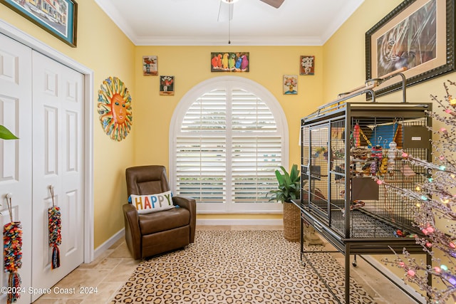 living area featuring ornamental molding, baseboards, and a ceiling fan