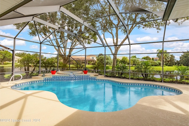 outdoor pool with glass enclosure, a patio area, a water view, and an in ground hot tub