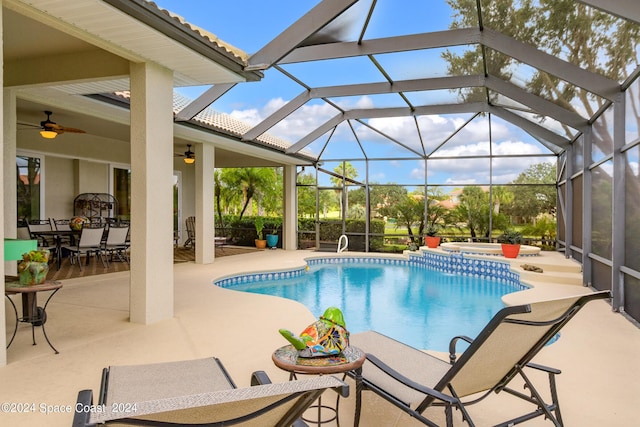 outdoor pool featuring a ceiling fan, a patio, glass enclosure, a jacuzzi, and outdoor dining space